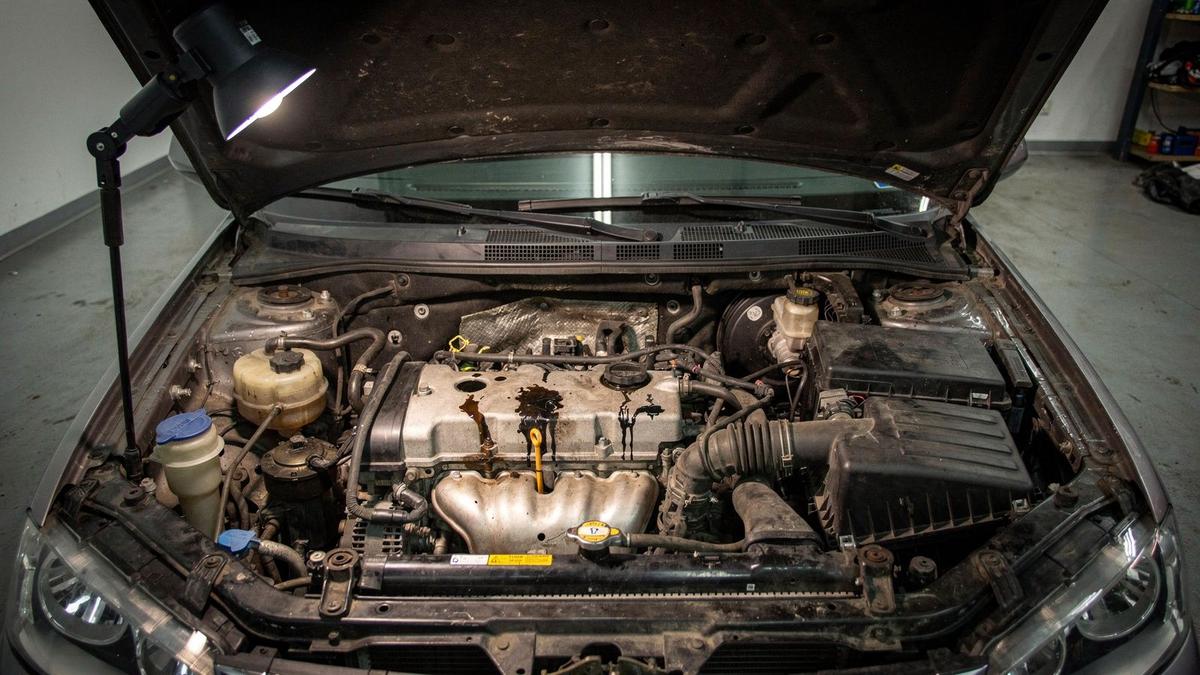 Annotated inspection photograph of a used car engine bay with four numbered defect markers